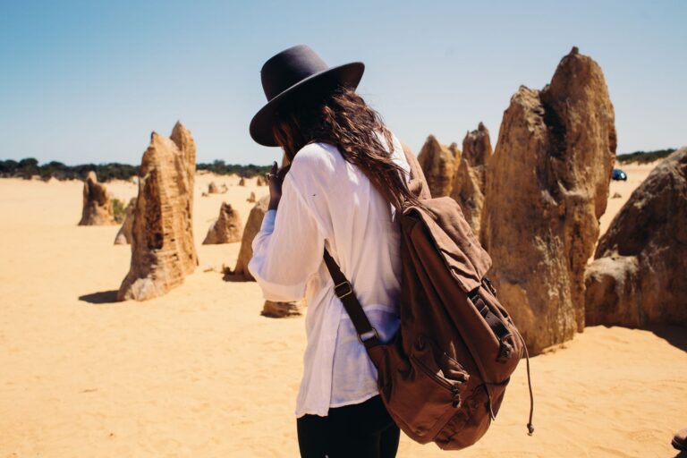 Junge Backpackerin startet ihr Work and Travel Abenteuer in Australien mit Rucksack am Flughafen