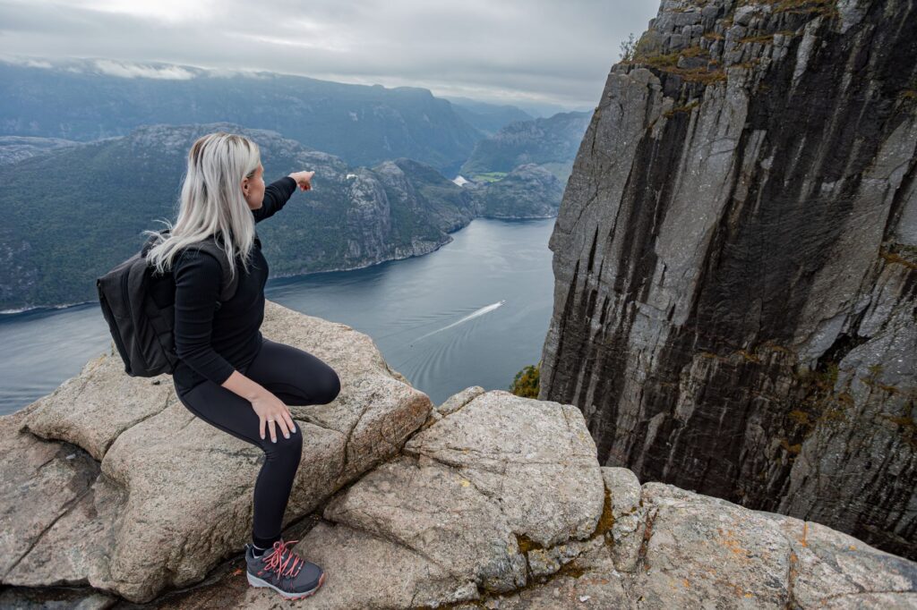 Junge Person plant den Neustart in Norwegen mit Notizen und Laptop am Schreibtisch