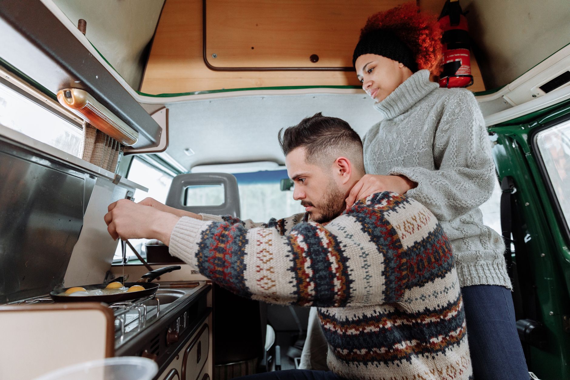 Junge Reisende kochen abends neben ihrem Van auf einem Campingplatz im Outback