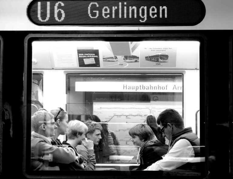 Junge Reisende sitzt mit Gastgeber in einem deutschen Wohnzimmer und plant gemeinsame Aktivitäten