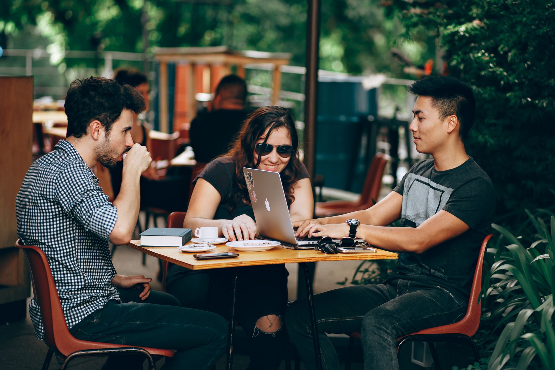 Freunde arbeiten gemeinsam in einem Café im Ausland während ihres Gap Years