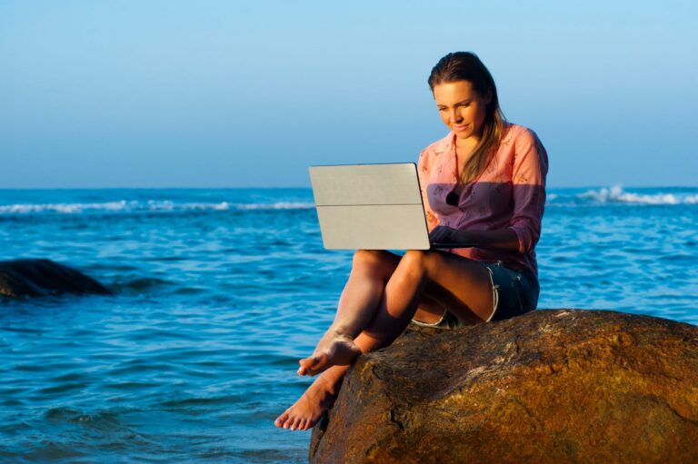 Junge Person arbeitet ortsunabhängig am Laptop und plant einen Auslandsaufenthalt