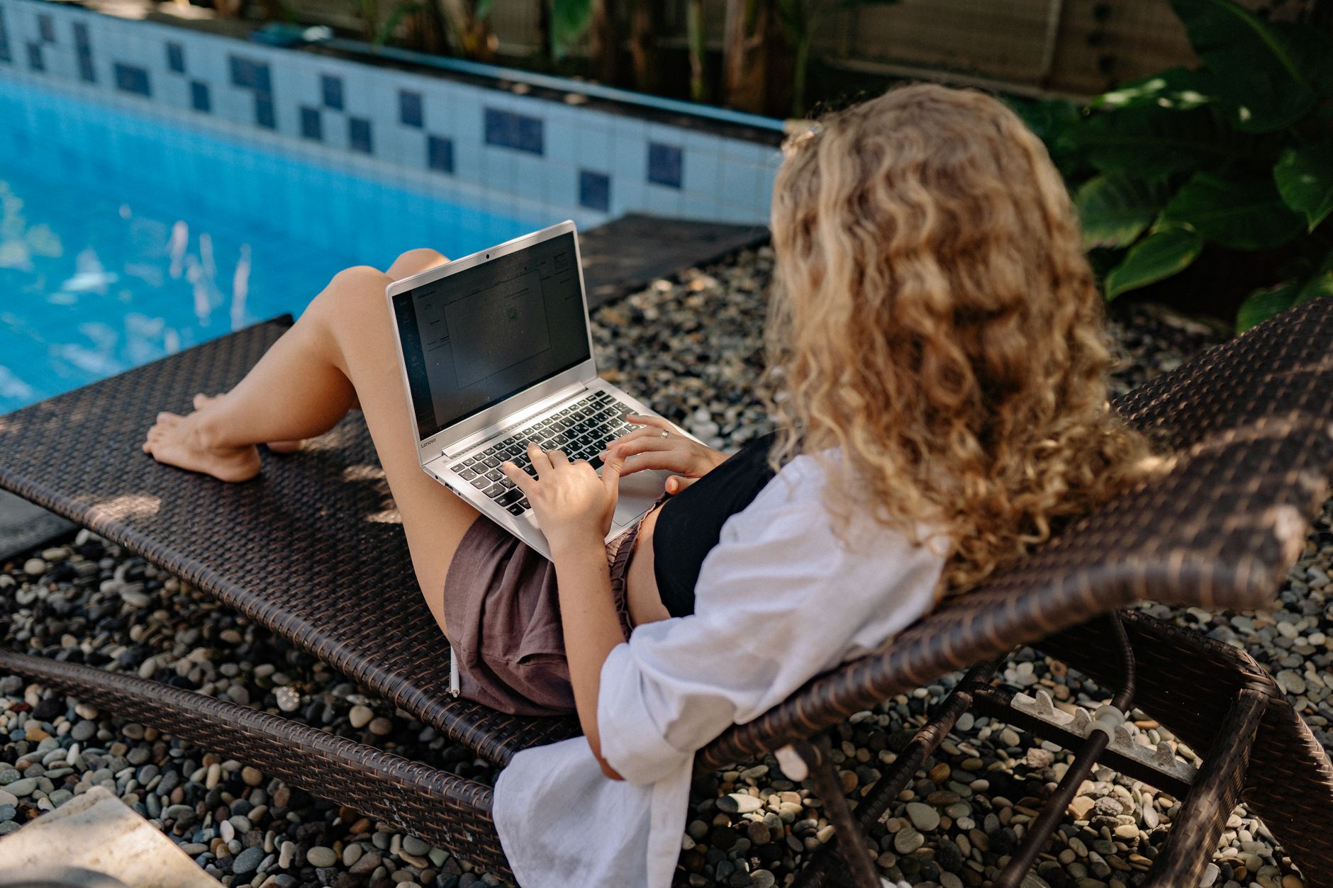 Junge Frau recherchiert internationale Remote Jobs am Laptop für ein Leben im Ausland