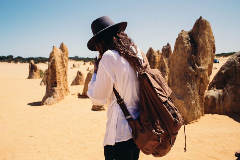 Junger Backpacker mit Rucksack am Flughafen startet sein Work and Travel Abenteuer im Ausland