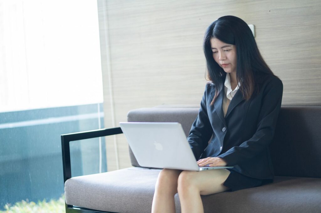 Junge Person arbeitet mit Laptop im Ausland und verbindet Job mit Reisen