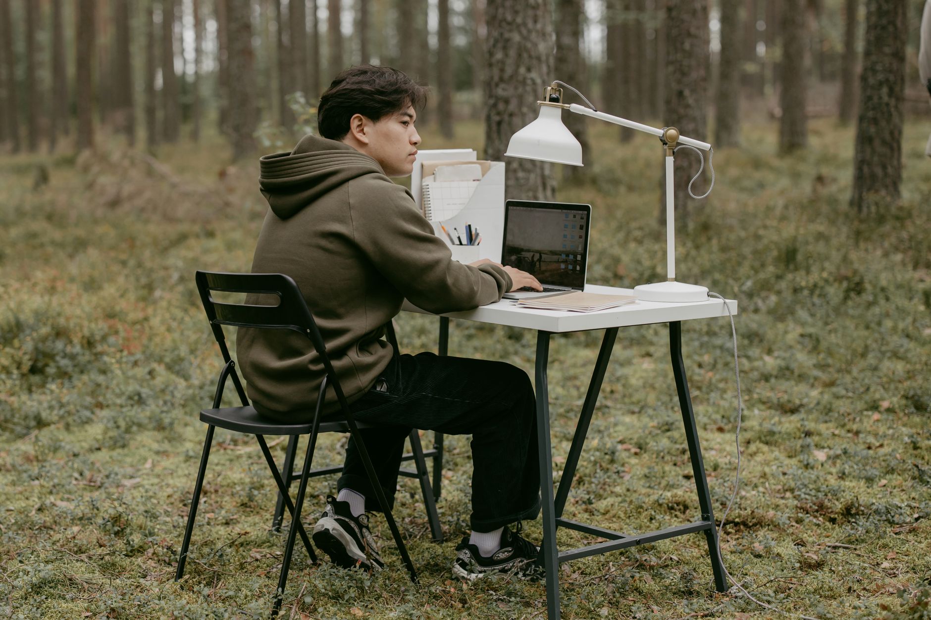 Remote Worker sitzt mit Laptop auf einer Terrasse und genießt eine flexible Workation in Deutschland