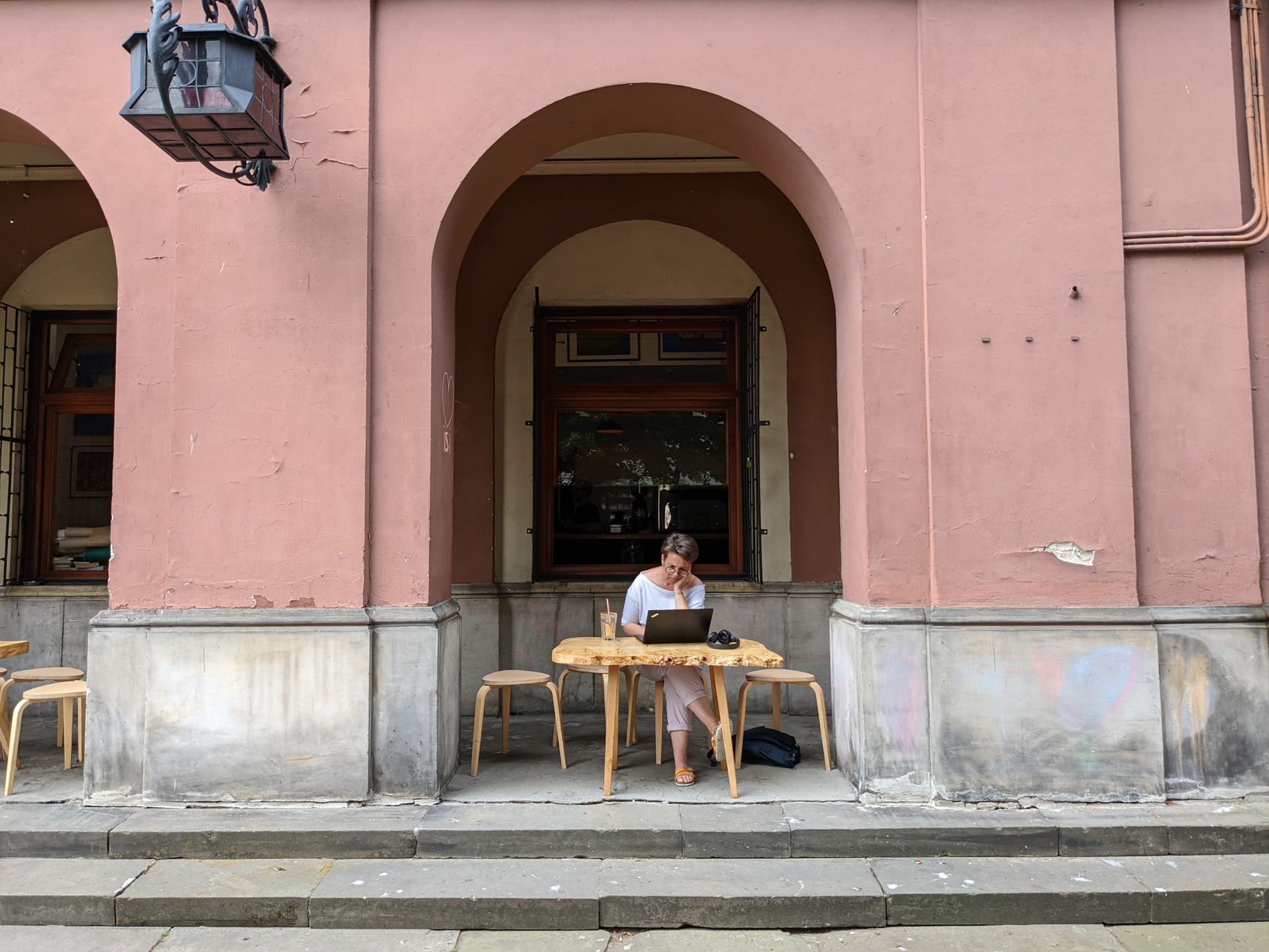 Remote-Worker plant seine Workation in Europa mit Laptop und Reisekarte am Tisch