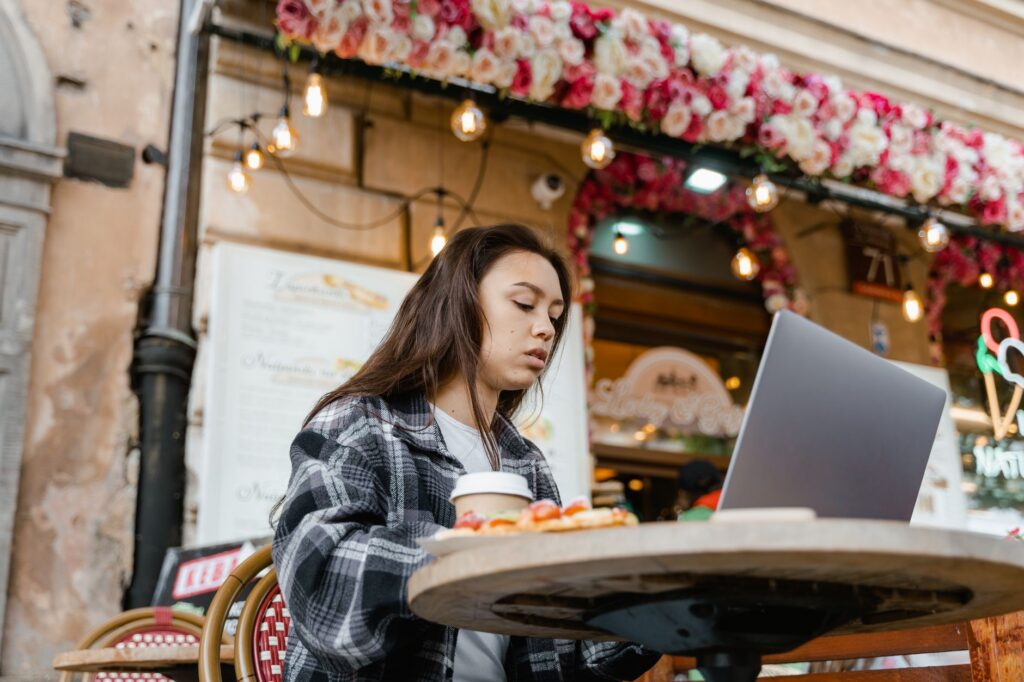Remote Worker sitzt mit Laptop in moderner Unterkunft und verbindet konzentriertes Arbeiten mit entspanntem Reisen im Ausland